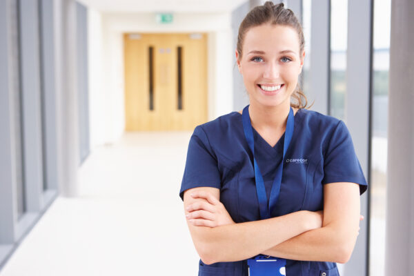 Female Nurse Standing In Hospital Corridor