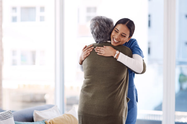 Young nurse hugging a senior woman