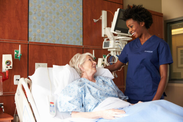 Nurse Talking To Senior Female Patient In Hospital Bed