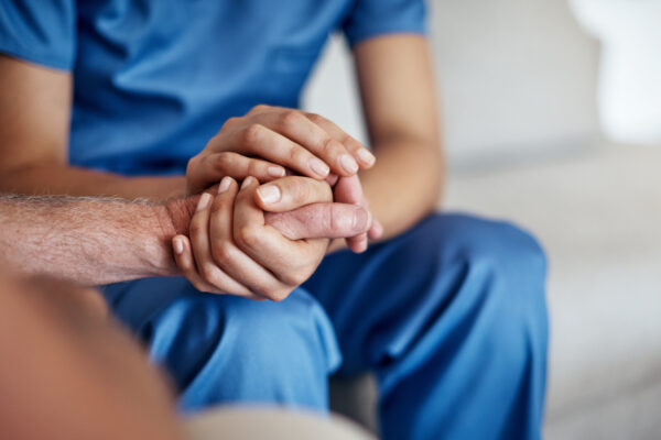 Female carer consoling a senior patient at the nursing home