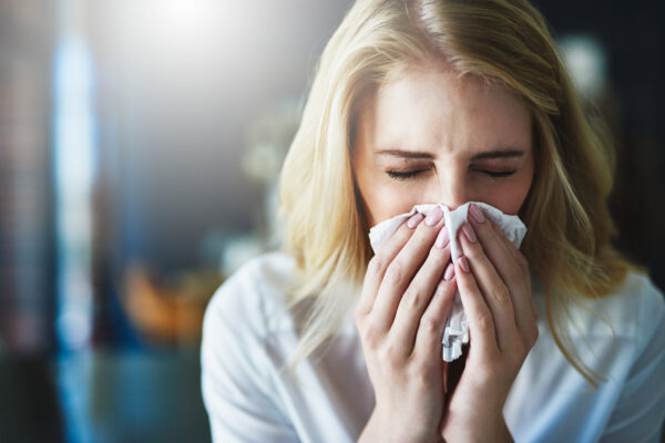 Woman using a tissue to sneeze