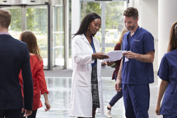 Staff In Busy Lobby Area Of Modern Hospital