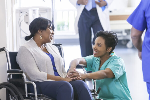 Female nurse in hospital with wheelchair patient