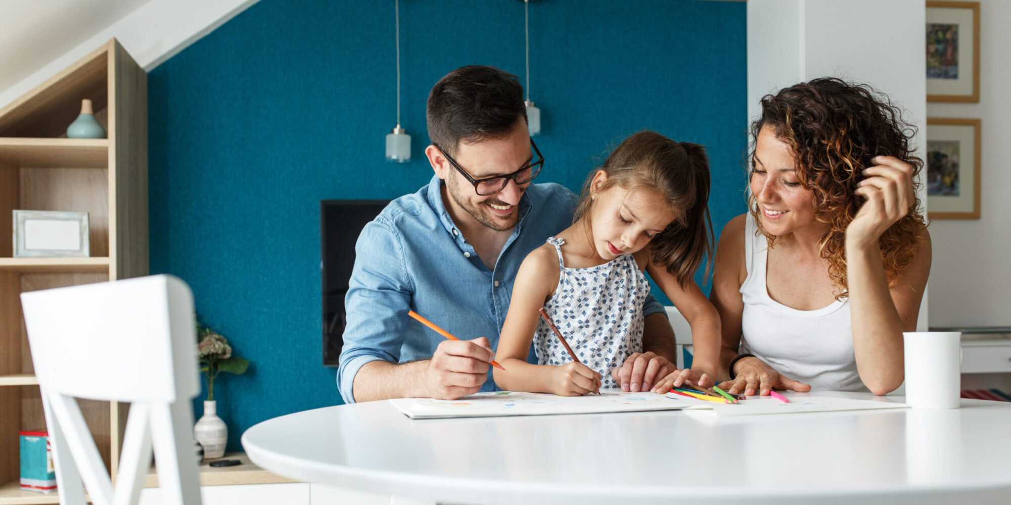 Father, mother and daughter drawing together