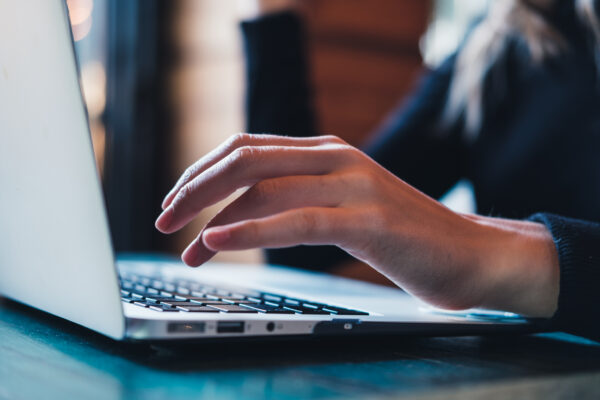 Woman’s hands using laptop.