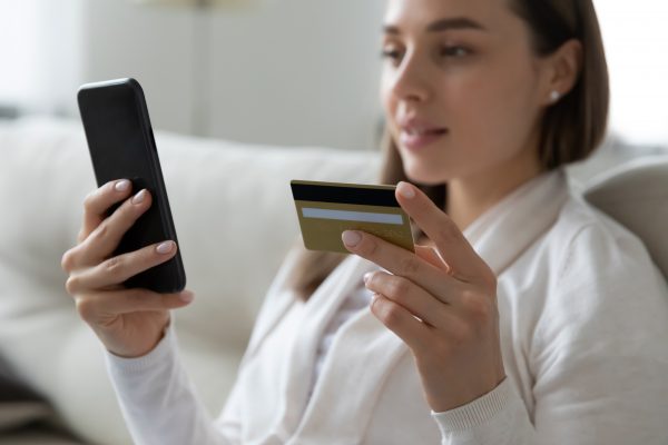 Woman making online payment using credit card and smartphone