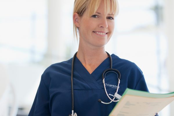 Smiling nurse holding medical record